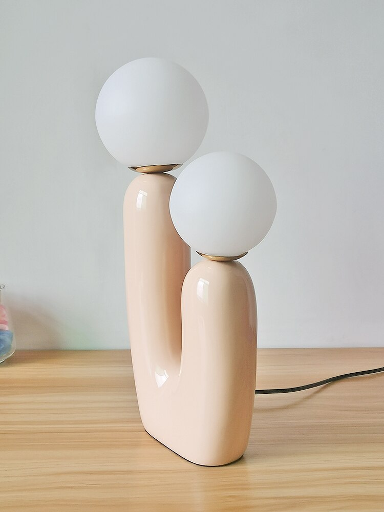 The Zenitude CACTUS Sculptural Table Lamp in smooth ivory with two rounded arms and frosted white glass globe bulbs, resting . - The Zenitude